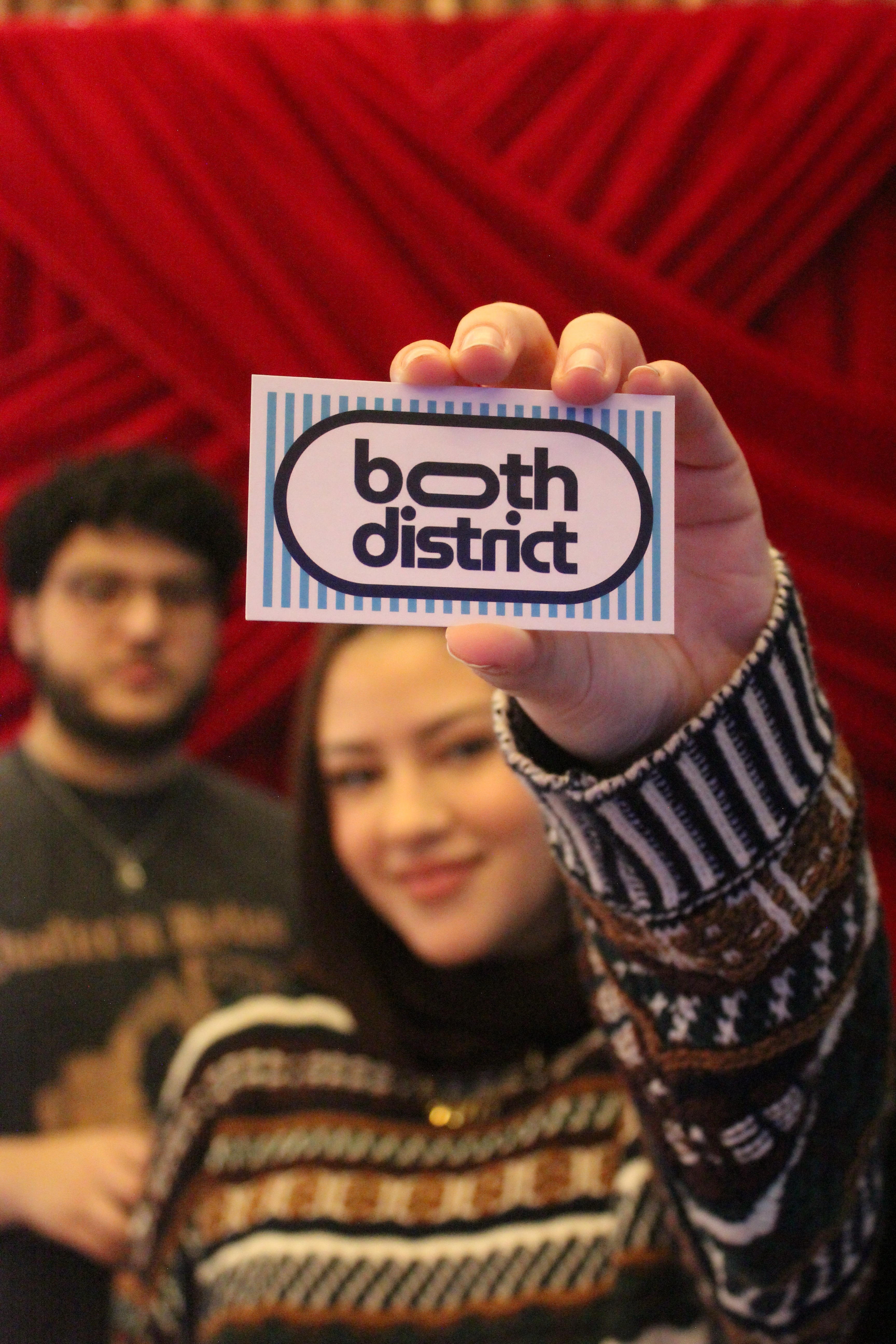 The Booth District founders holding their business card at an event in Mississauga